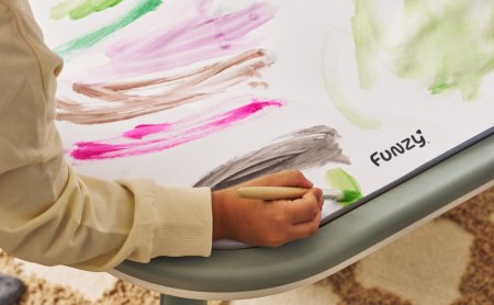 Kind malt auf Spieltisch